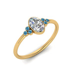 Load image into Gallery viewer, petite-bezel-set-oval-shaped-diamond-engagement-ring-with-blue-topaz-in-yellow-gold-FD9175OVRGICBLTOANGLE2-NL-YG
