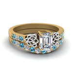 Load image into Gallery viewer, celtic-emerald-cut-diamond-wedding-ring-set-with-blue-topaz-in-yellow-gold-FDENS2255B1EMGICBLTO-NL-YG_deeef43e-72ca-476a-be28-dacfc14207e3?v=1757056978
