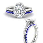 Load image into Gallery viewer, oval-shaped-diamond-bezel-solitaire-ring-with-sapphire-band-in-white-gold-FD11229OVGSABLANGLE3-NL-WG_69eaaab5-48f3-4a7e-805d-eff957a3fb68.jpg?v=1758702938
